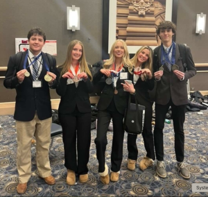 WINNERS: Senior Lexi Kuzak (middle) poses with fellow DECA competitors at the Illinois North Region DECA competition. “I’m very excited to practice my business skills,” Kuzak said as she qualified for the state competition in March. 